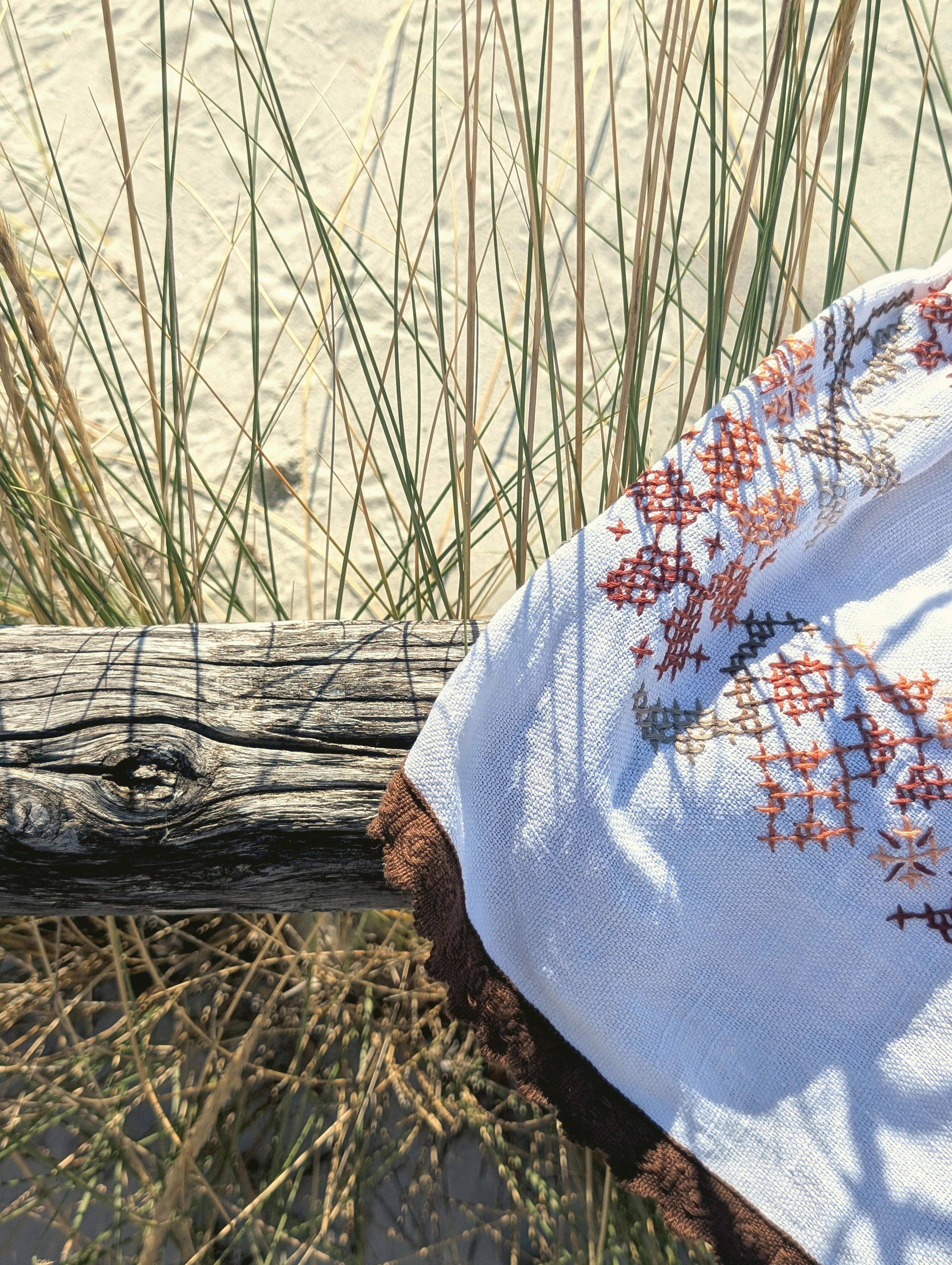 Shorts DELAMIA in cotone ricamato d'epoca appoggiato su un legno di mare tra le dune