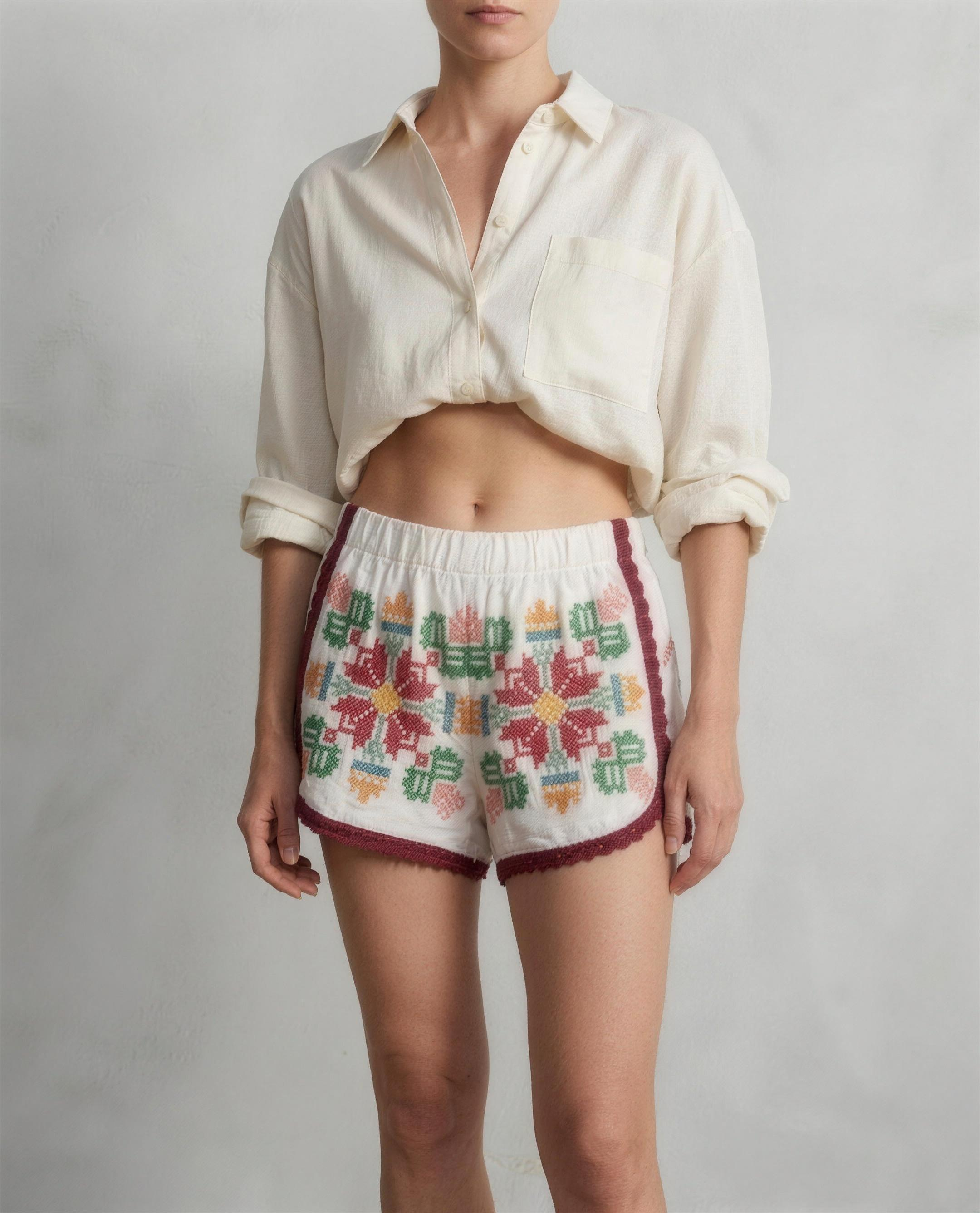 Shorts Luminaria DELAMIA indossati — ricamo folk multicolore, vista frontale in studio