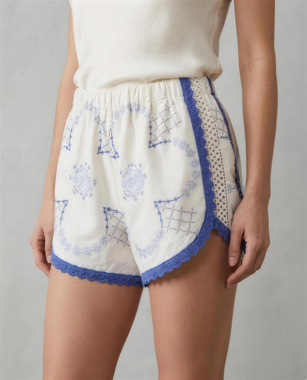 Shorts Loggia DELAMIA indossati — geometrie blu e merletto, vista frontale in studio
