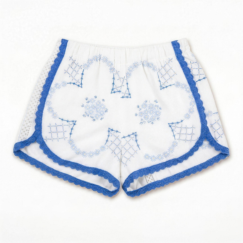 Shorts Loggia DELAMIA — ricami geometrici blu e merletto a giorno su bianco, vista frontale