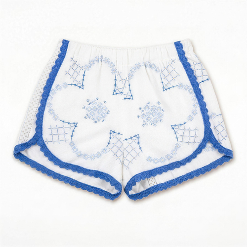 Shorts Loggia DELAMIA — ricami geometrici blu e merletto a giorno su bianco, vista frontale