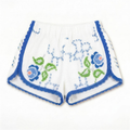 Shorts Verzura II DELAMIA — foglie verdi e fiori blu e corallo su bianco, vista frontale