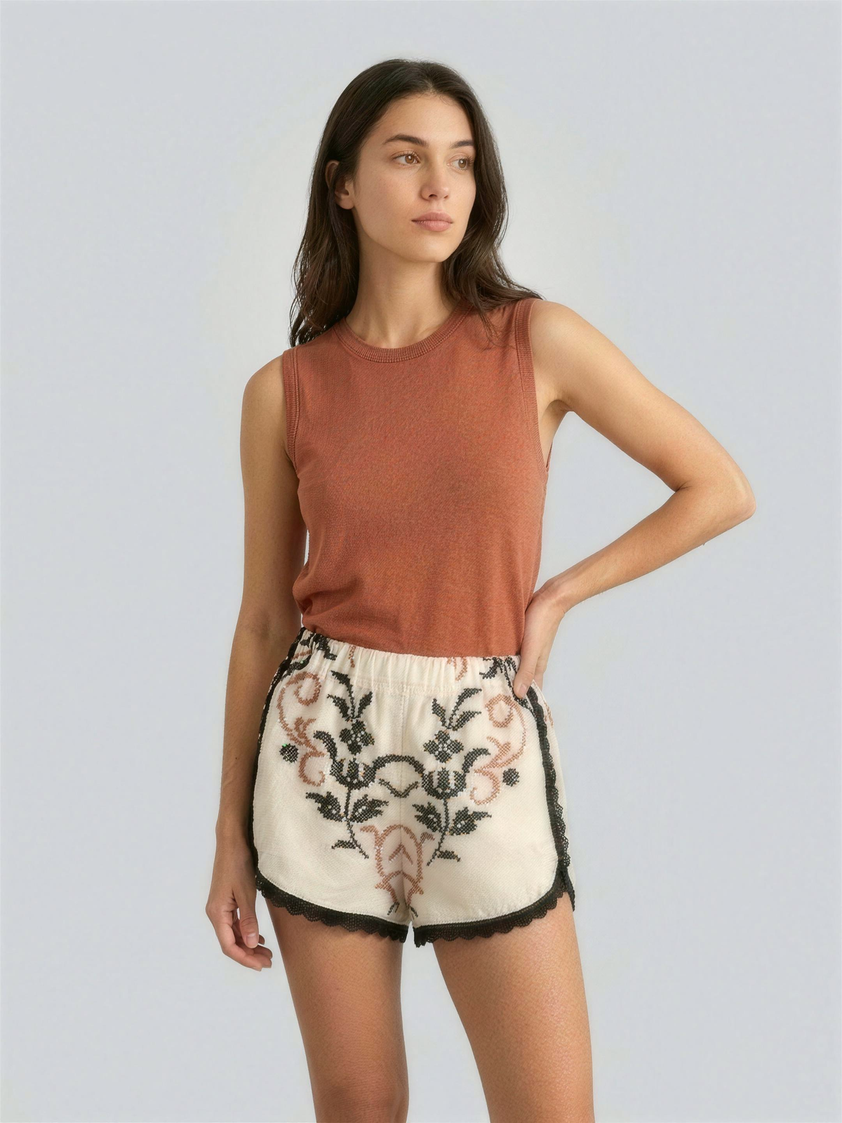 Rare Collection — shorts Vespro DELAMIA, top terracotta su fondo grigio